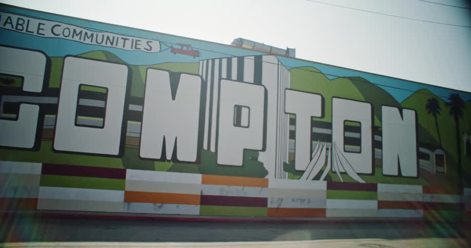 The graffitistyle letters of compton pop against the colorful backdrop capturing the citys unique energy