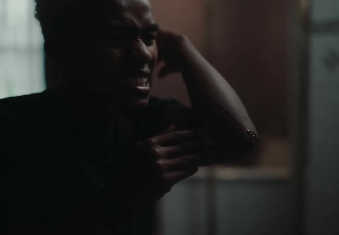 A young man inspecting his elbow in front of a mirror in the bathroom