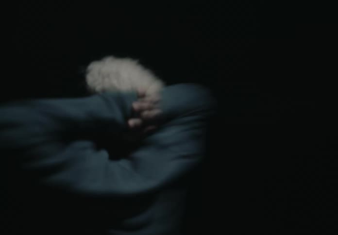 A man is spinning around in the dark