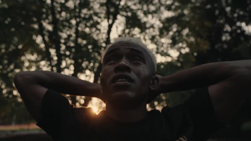 A man is stretching by the tree