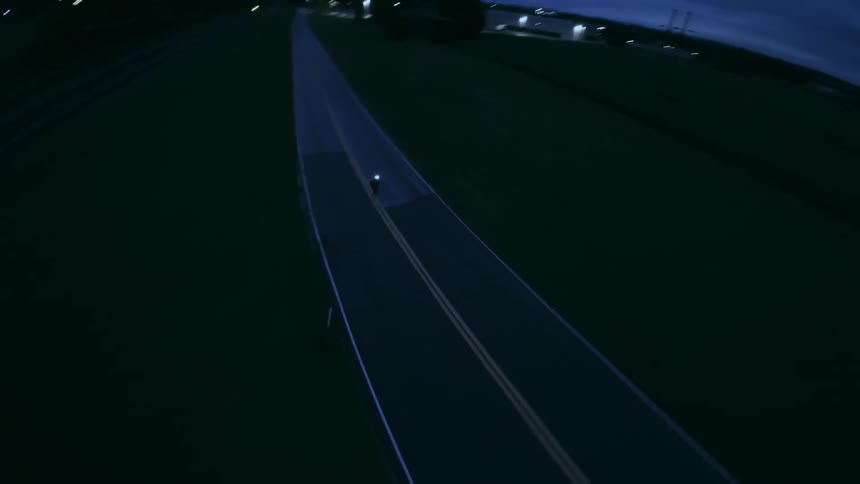 A person is doing a wheelie on their motorcycle while riding on the road