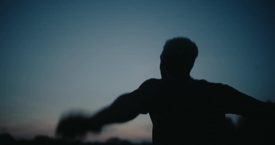 A man is swinging his arms outside