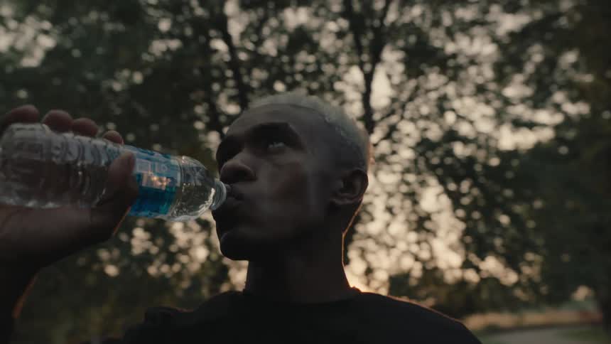 A man is drinking from a water bottle