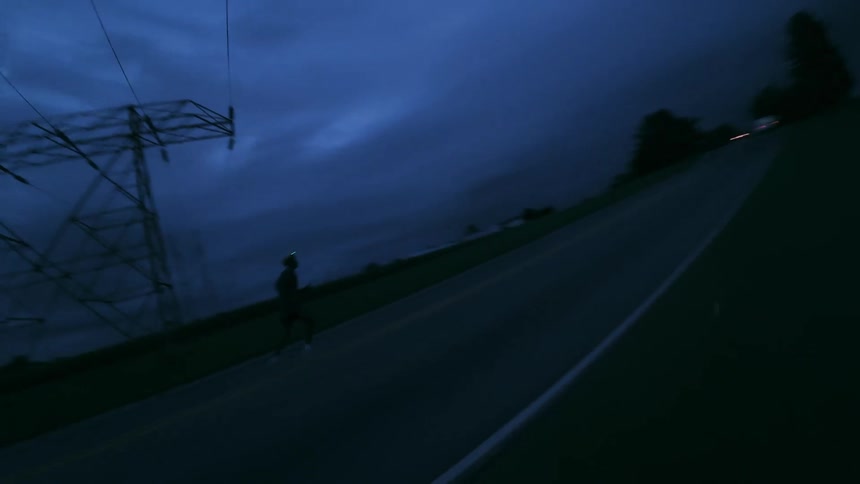 A man is running on the road under power lines