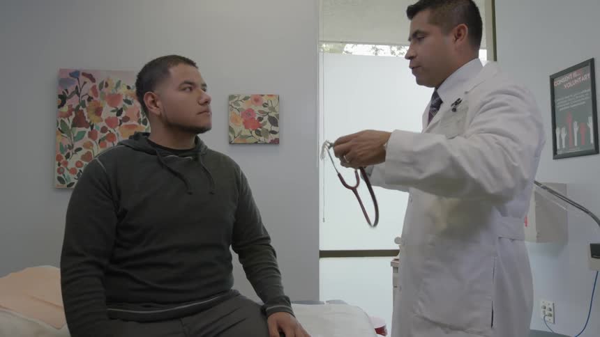 Dr. examining a patient with his stethoscope and then shaking his hand before walking away