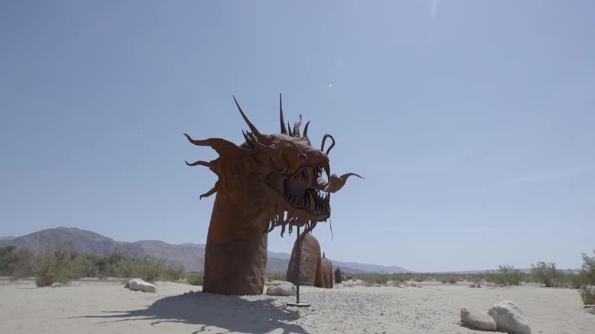 Dragon statue seemingly submerged partially in the ground on a clear day