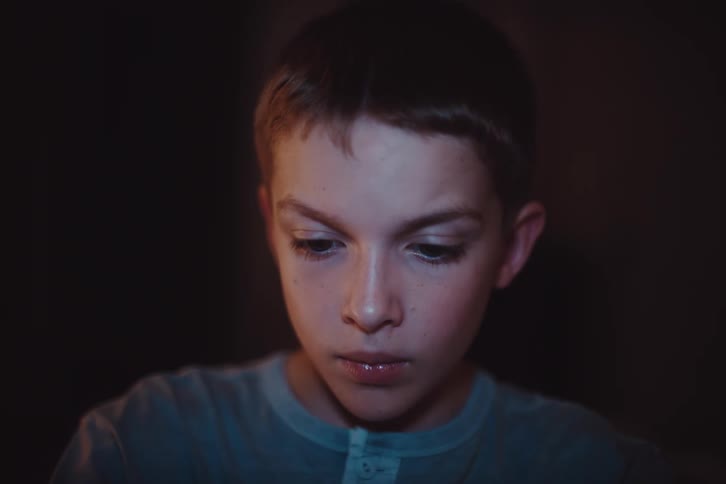 Portrait of a boy interacting while in a dimly lit room