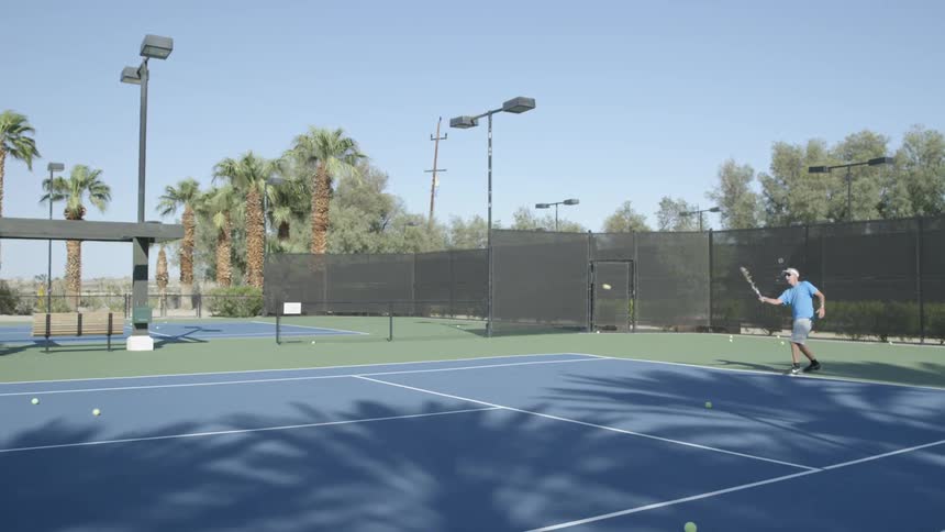 A man is playing tennis on a sunny day