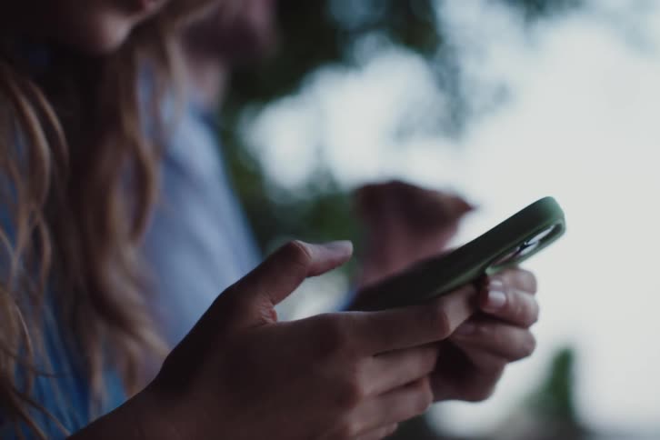 Hands typing on an iphone