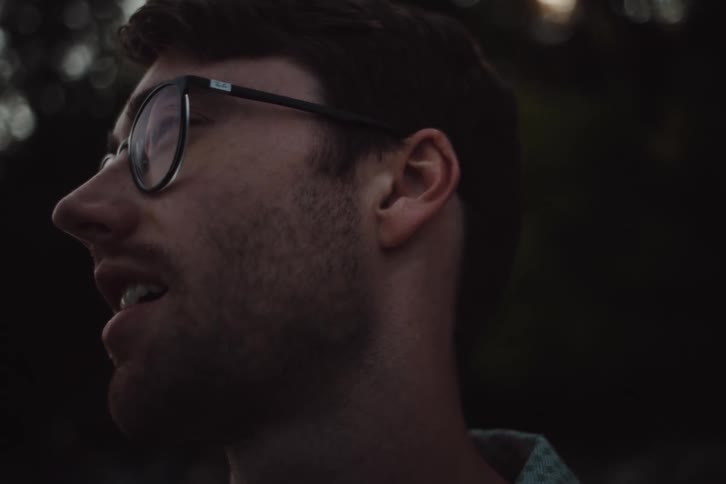 Closeup of a smiling man standing outdoors in the woods