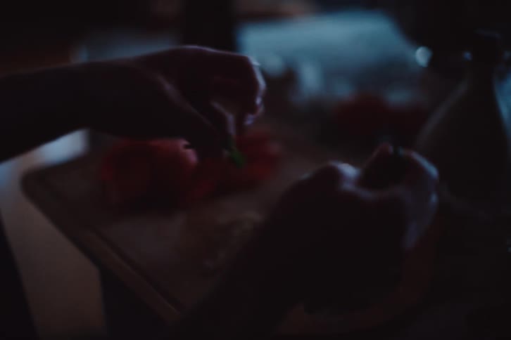 A person is preparing food in a dimly lit room