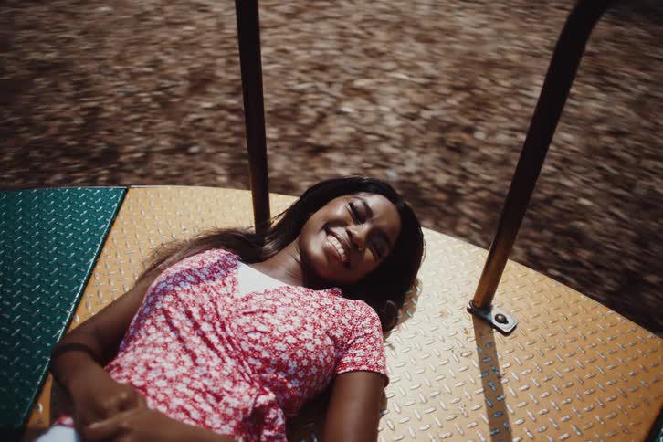 Happy young woman lying on a spinning toy