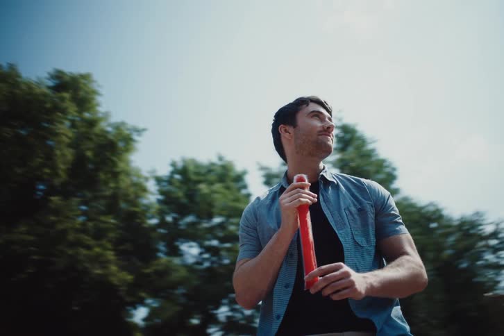 Man holding a red stick while having fun on a spinning object