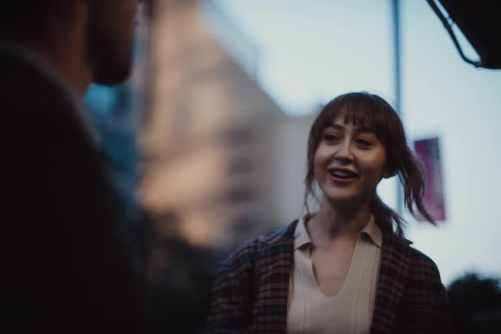 Woman and man on the sidewalk of a metropolis talking