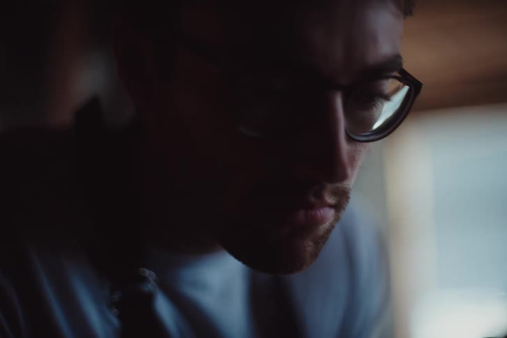 Portrait of a man wearing glasses in a focused indoor space