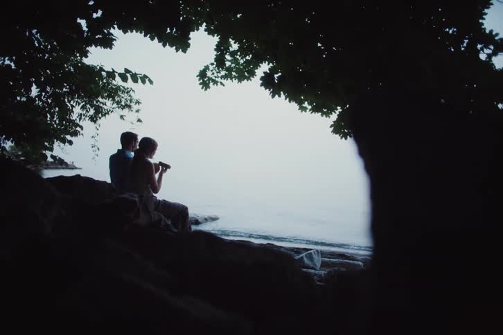 A couple are eating by the shore