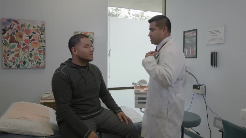Doctor greeting a patient with a handshake and then removing his stethoscope
