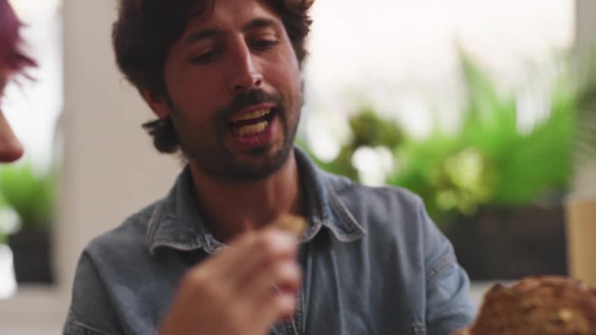 A group of people share a meal passing food and enjoying conversation