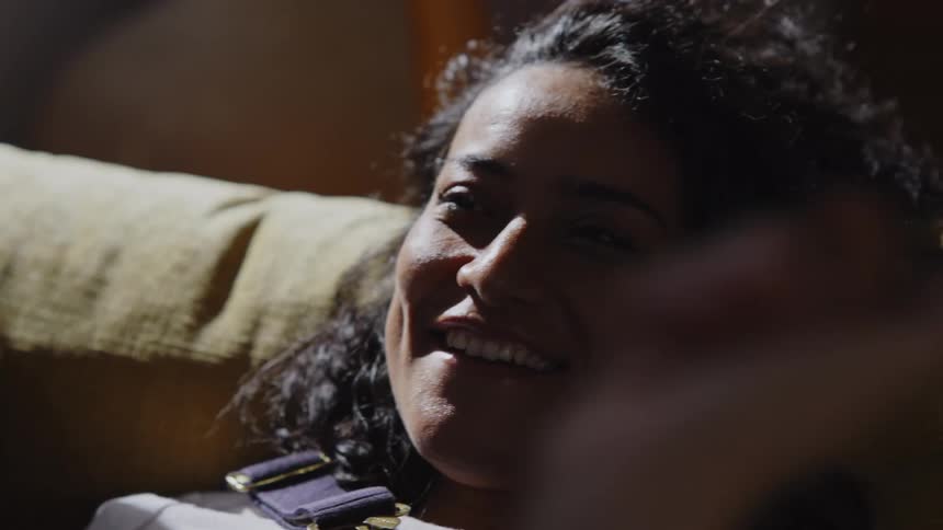 Portrait of a happy woman sitting while another person is doing hand gestures