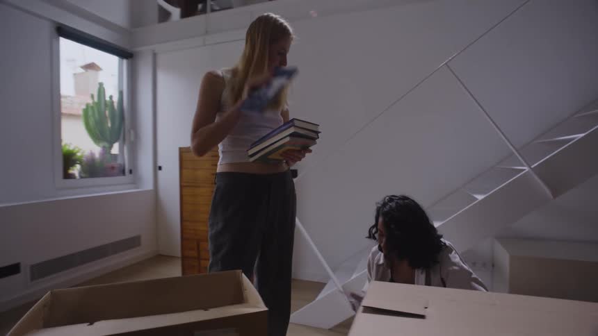 Women unpack books from boxes