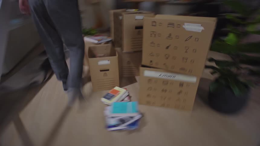 Two women walking into a living room with boxes and starting to assemble