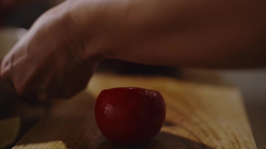 A woman is slicing a tomato