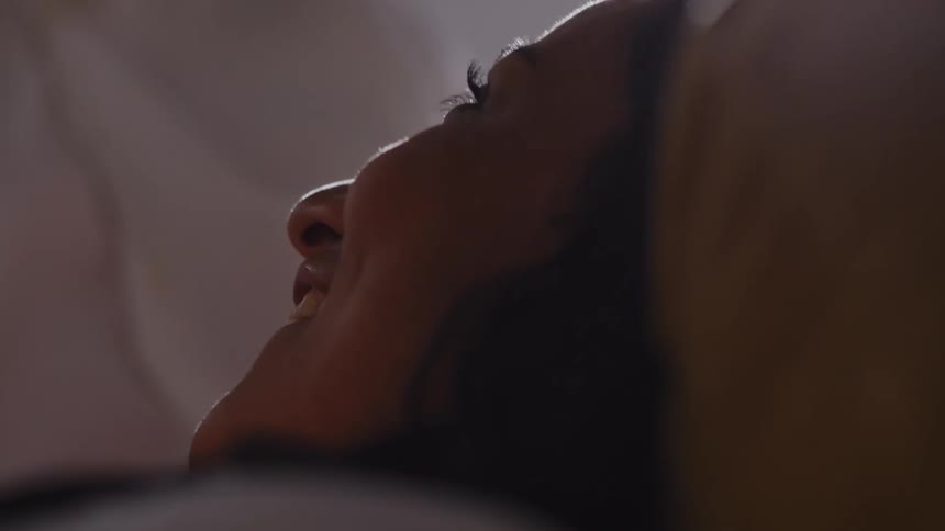 Woman lying on her back and blonde woman sitting nearby smile while talking with each other on a sunny day
