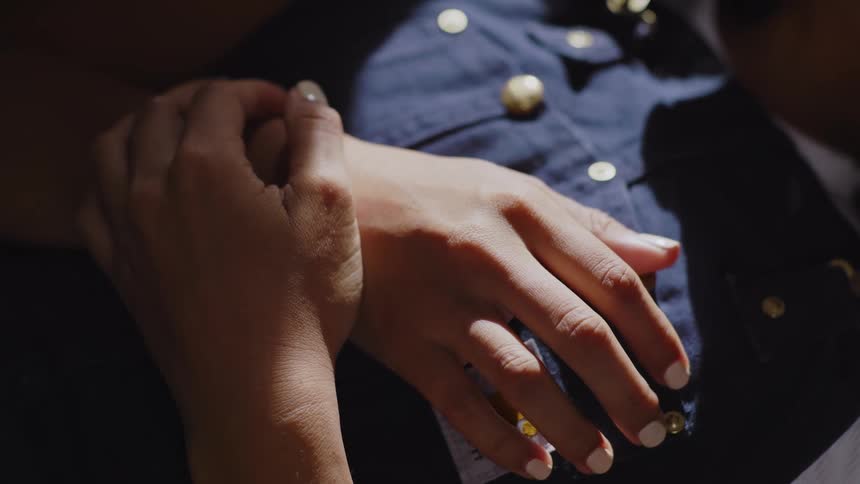 Womans hands on her chest while lying down