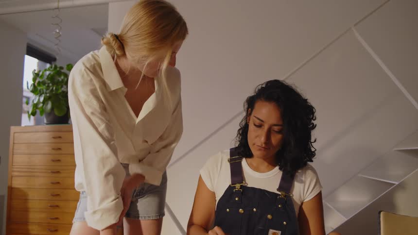 Two women talk as one sketches