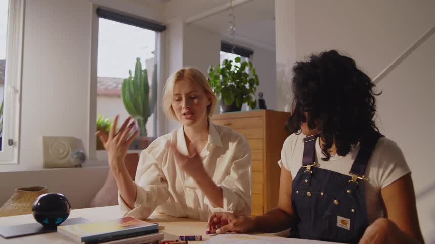 Two women talk at the table