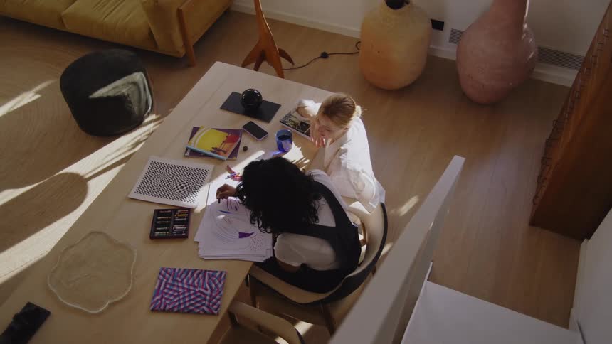 Two women talk and one is drawing