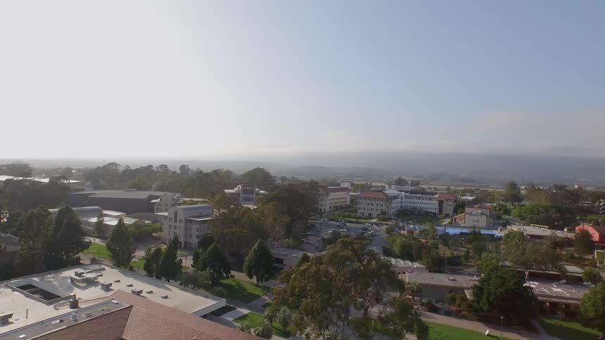 Aerial footage panning over a quaint town with tree lined streets