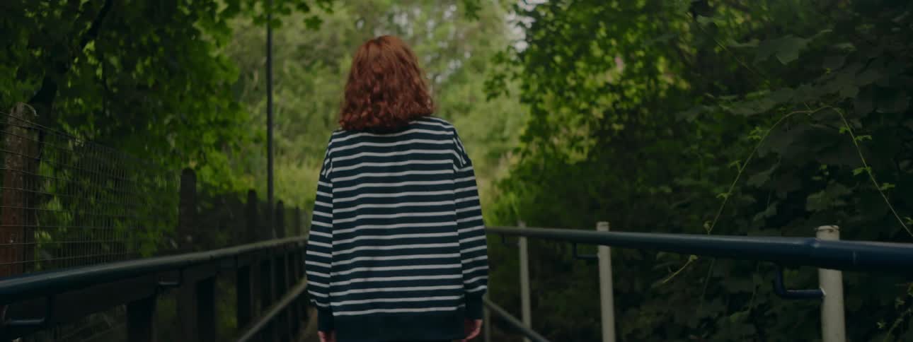 Womans vision on her back walking down a trail in an environment surrounded by trees