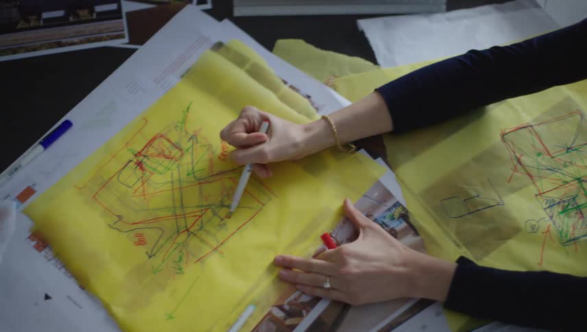 Two people with pens working on a project