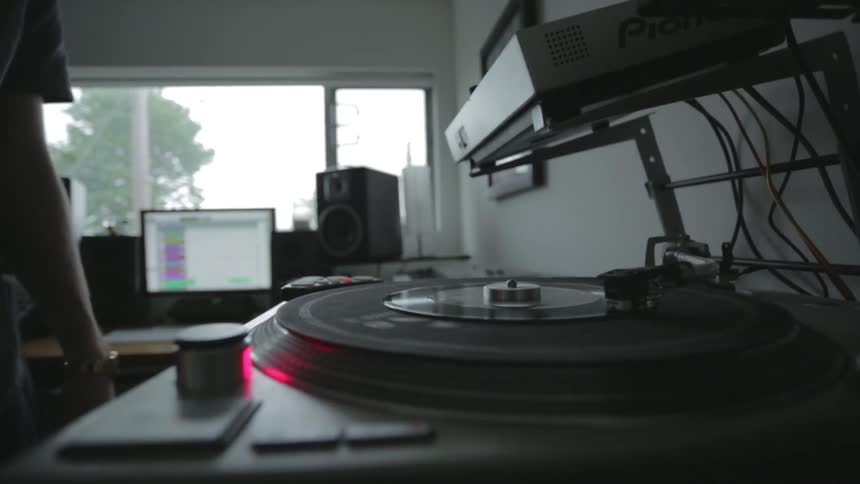 Person starts a record on a turntable