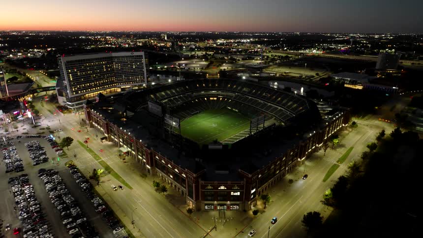 A large football stadium illuminated at night ready for a game under the lights