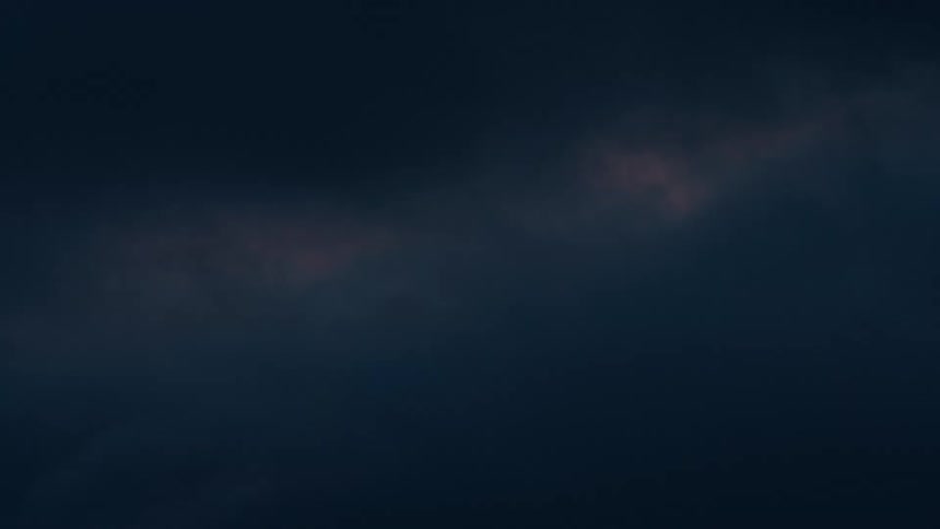 A dark almost black background with soft hazy light flares creating a dreamy ethereal atmosphere