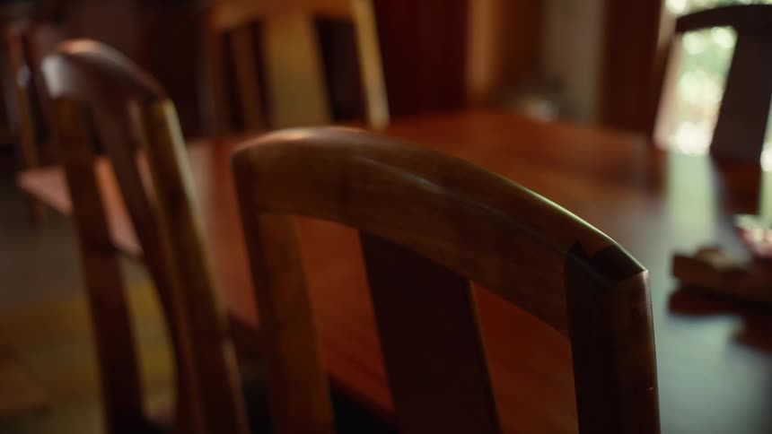 Close up of wooden chairs at a varnished table
