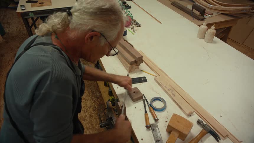 A clip of a carpenter carving a wood