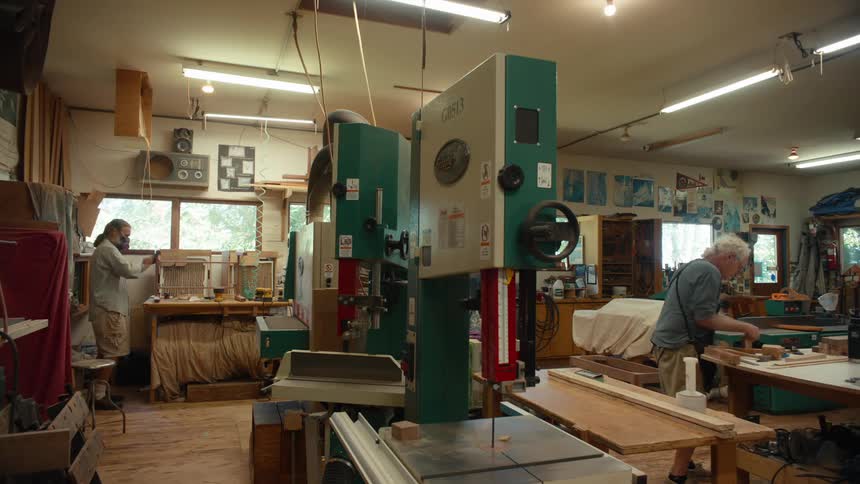 Two people work inside a capentry workshop