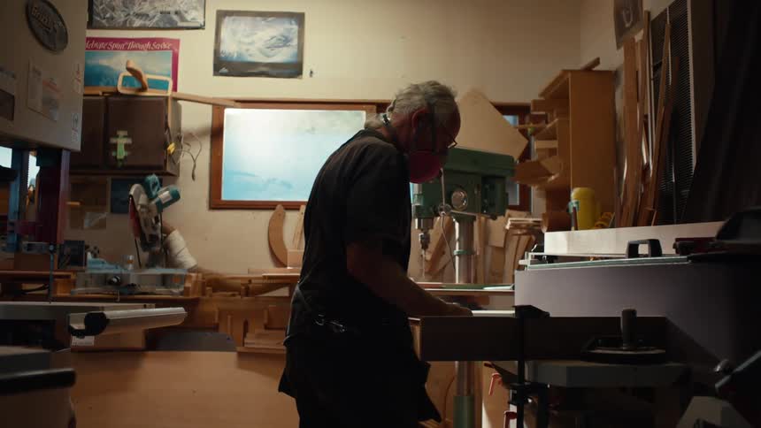 A man is working on a bench in his workshop