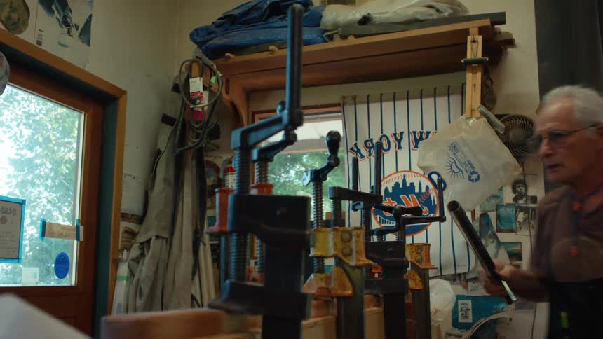 A man is tightening clamps on the wood