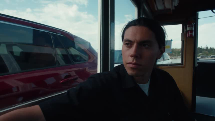 A man is sitting by the window inside