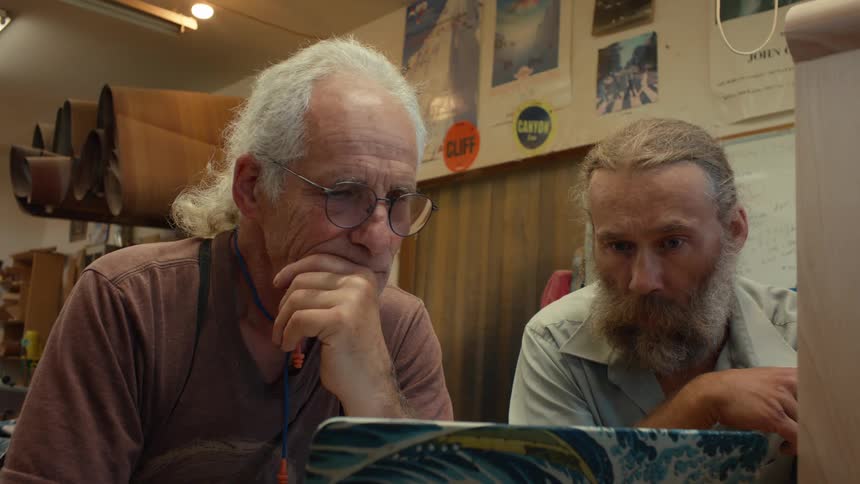 Two men are looking at a laptop