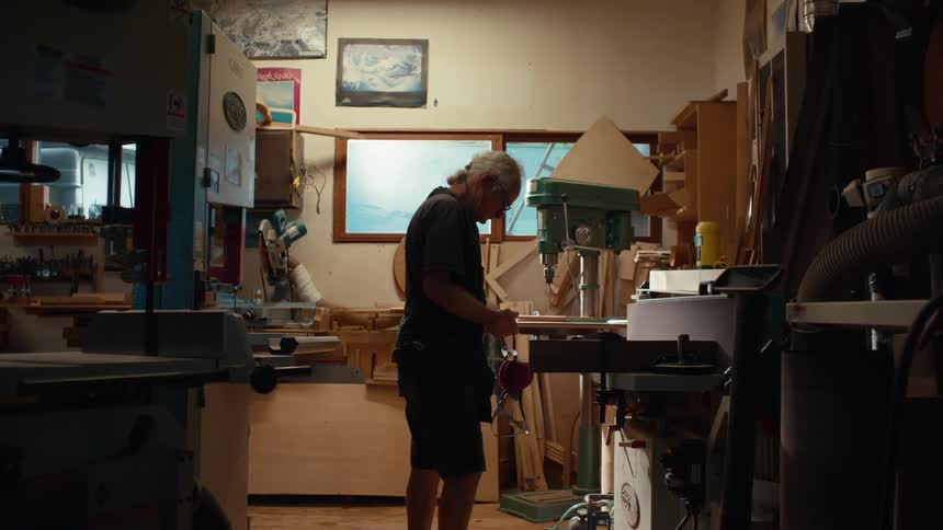 Carpenter in a workshop putting on a protective mask