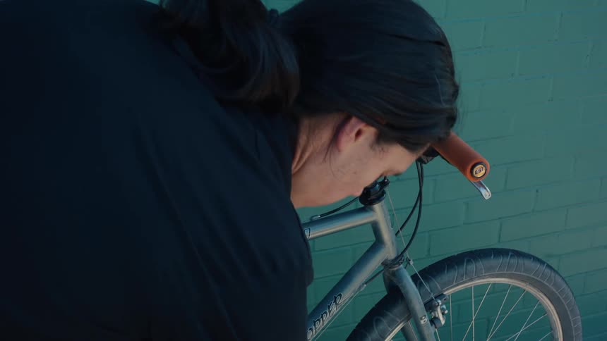 Man waiting for some items in his backpack while standing next to his bicycle
