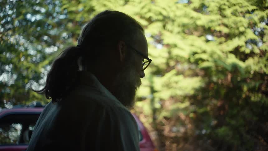 A man is talking outside by the tree