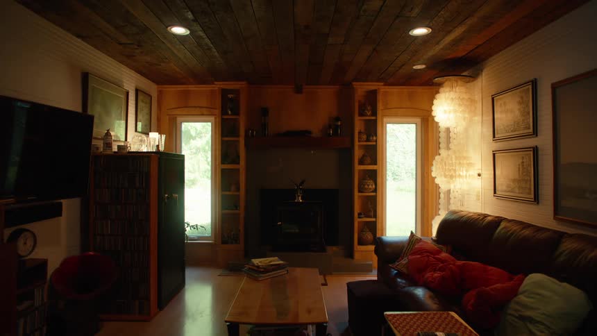 A chimney is near the windows of the living room