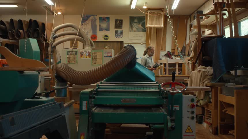 Carpenter operating a machine in a workshop environment