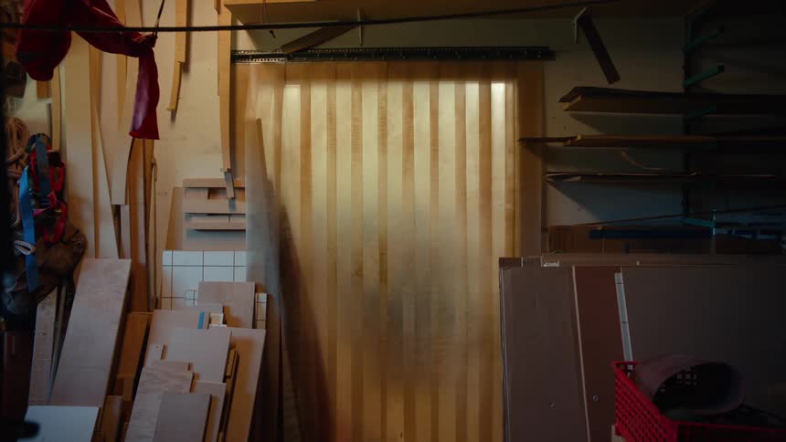 Carpenter carrying a soft baby bottle and passing through a semitransparent curtain in an indoor space